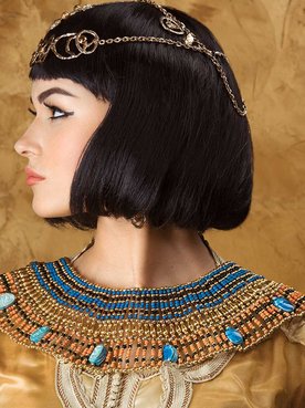 Imagem de uma modelo vestida de Cleópatra. Com uma roupa dourada e cabelo chanel
