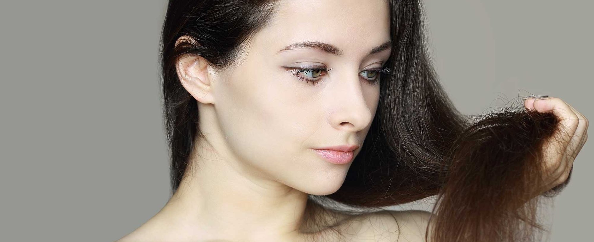 Modelo branca olhando seu cabelo