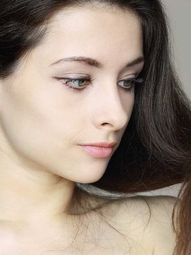 Modelo branca olhando seu cabelo