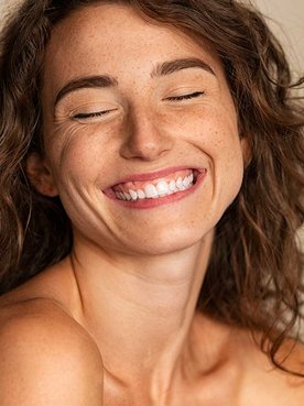 Modelo branca sorrindo com os olhos fechados