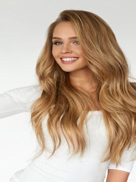 Mulher passando spray no cabelo