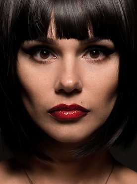 Mulher branca com batom vermelho e cabelo chanel preto com franja
