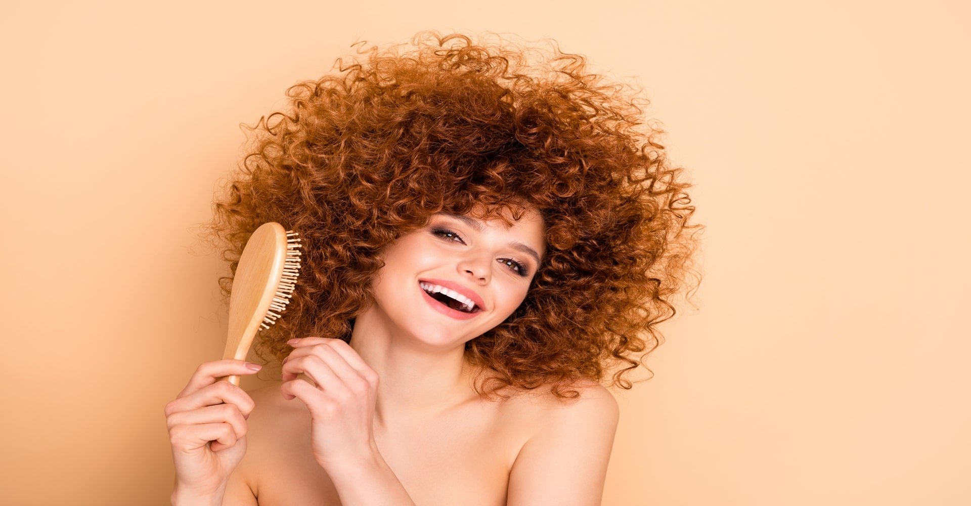 Mulher sorrindo com escova de pentear no cabelo