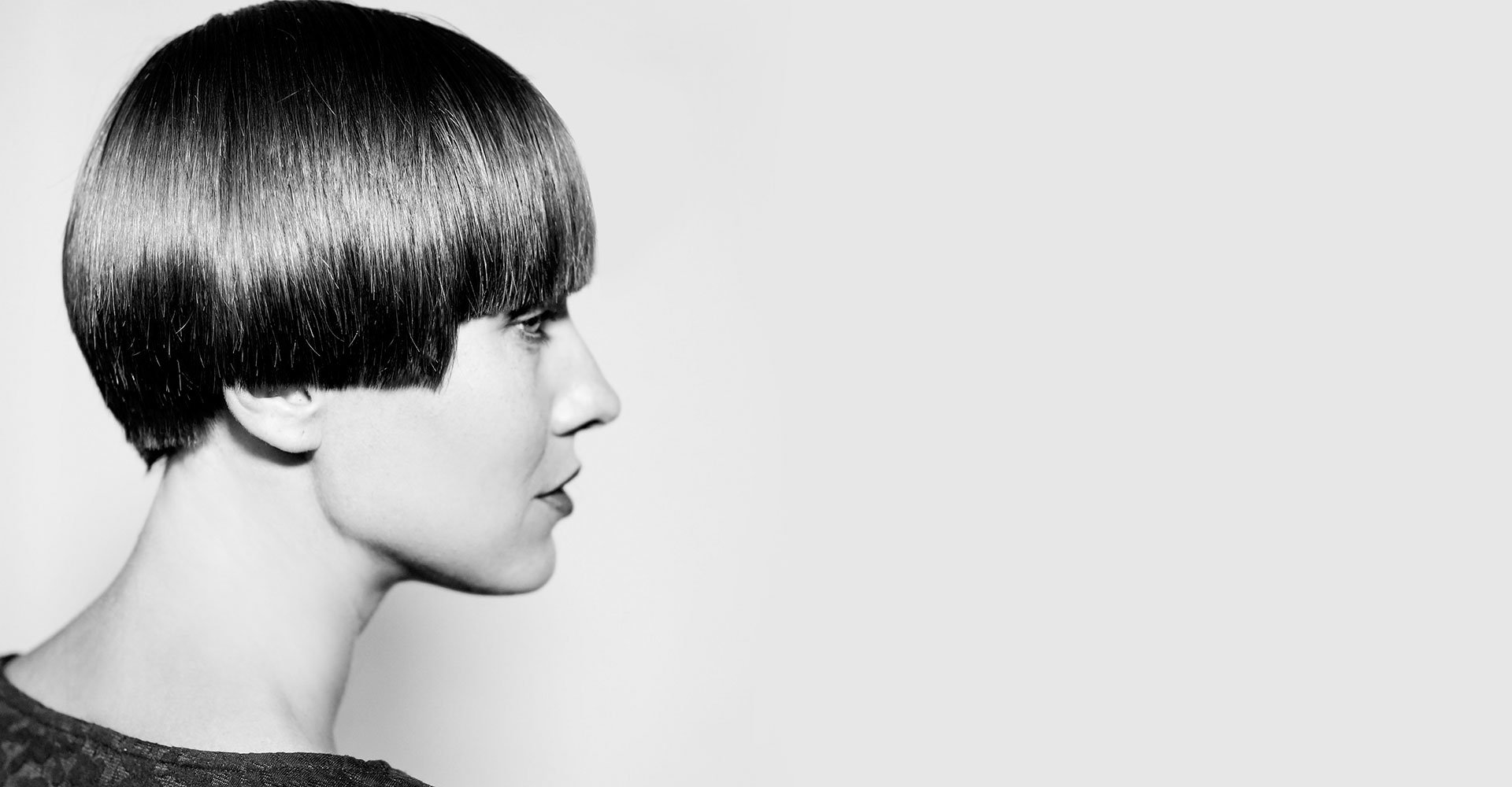 Foto preta e  branca de uma mulher com o corte de cabelo anos 90. Chanel acima da orelha