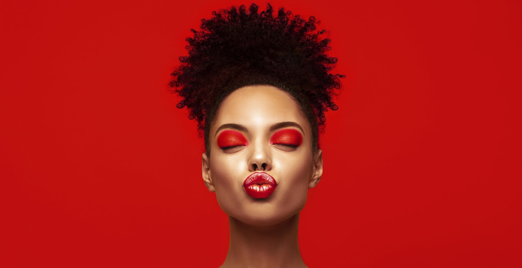 Imagem de mulher negra, com coque e fazendo biquinho.