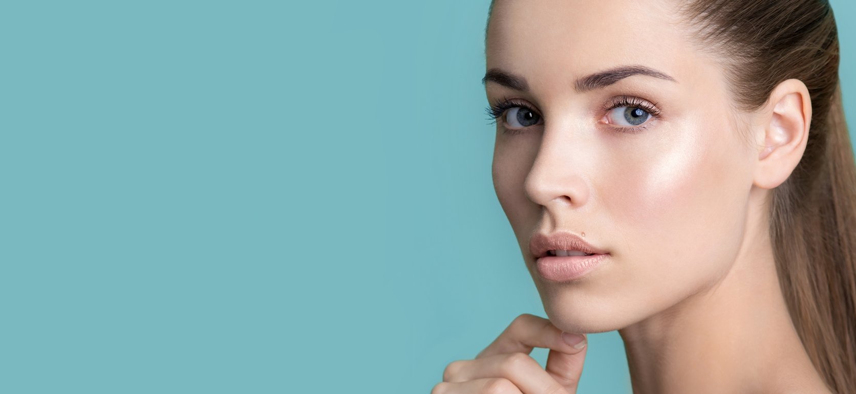 Imagem de uma modelo branca com a mão no queixo,