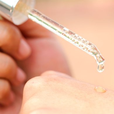 Pessoa aplicando sérum facial no dorso da mão
