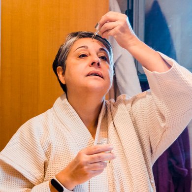 Mulher madura aplicando sérum facial