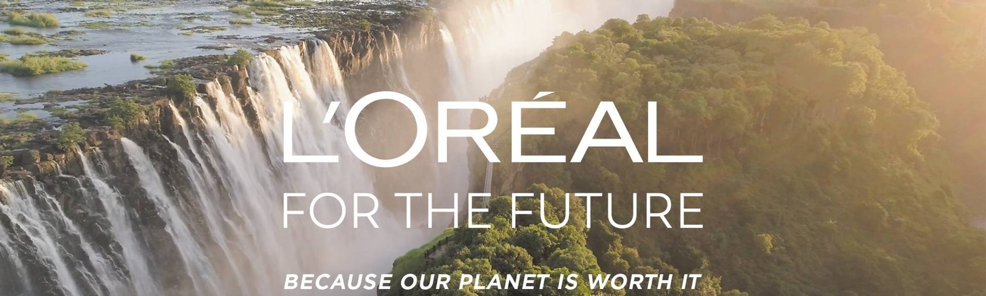 Uma floresta com uma grande cachoeira ao fundo e o texto L'Oréal for the Future
