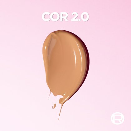 Textura do Protetor Solar facial com cor Expertise Efeito Makeup de L'Oréal Paris no tom 2.0 sobre fundo rosa claro.